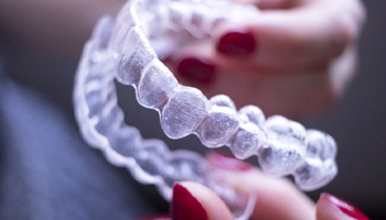 Woman holding a pair of Invisalign aligners