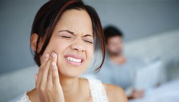 Woman in pain holding jaw