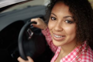 Woman with dark hair wearing braces as an adult