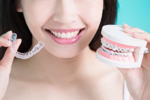 Woman with straight teeth comparing Invisalign vs. braces