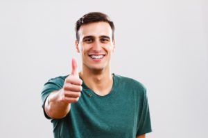 Confident man giving thumbs up for braces as an adult