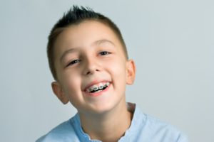 Smiling little boy with braces, undergoing phase 1 orthodontic